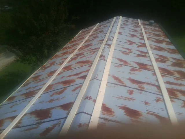 Rusted metal roof panels with new wood purlins before replacement — Storm Damage Roof Repair in Marcola by Roofing Brothers