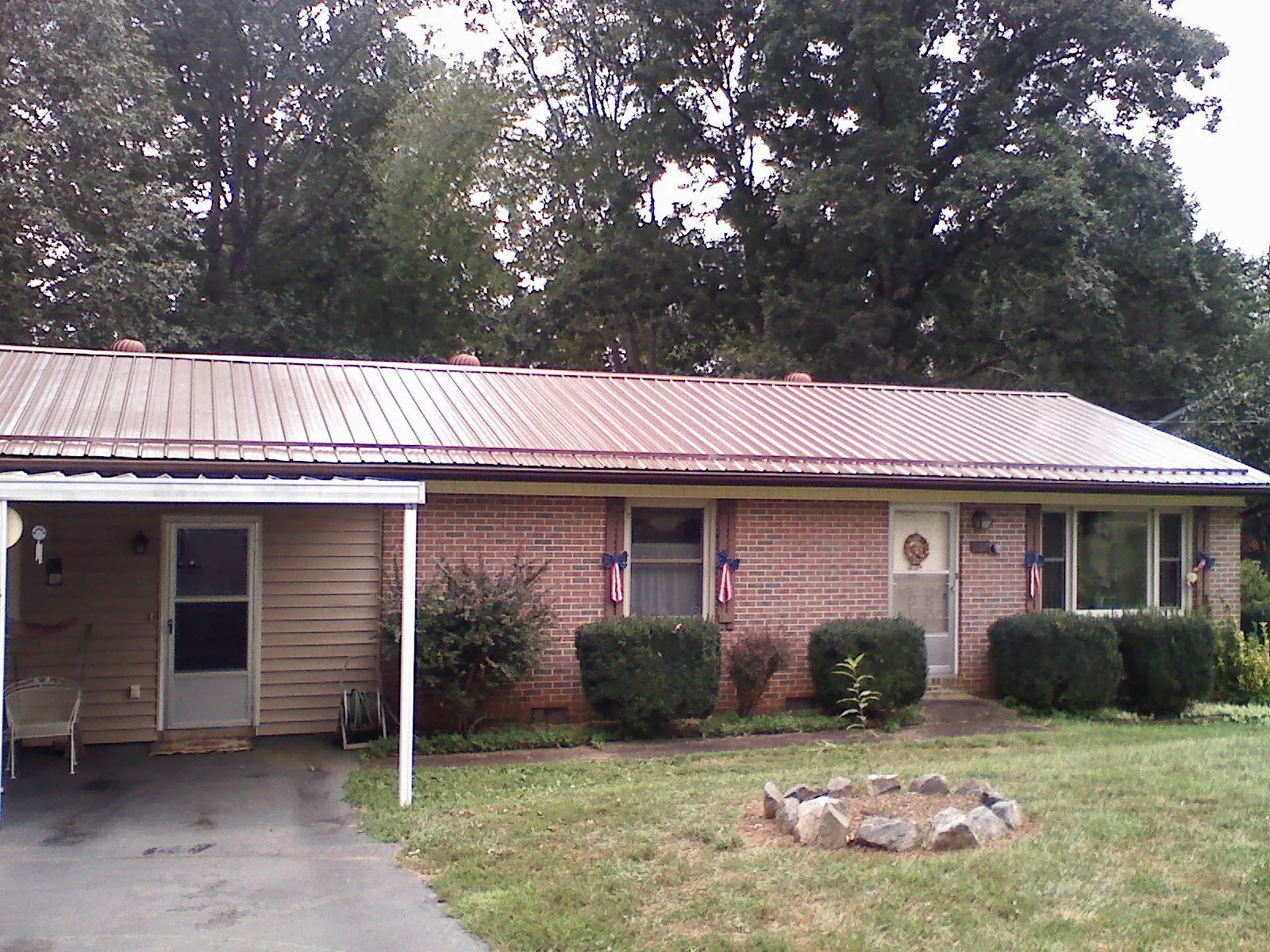 Bronze metal roof and carport on a brick ranch home — Roof Repair work by our crew in Marcola