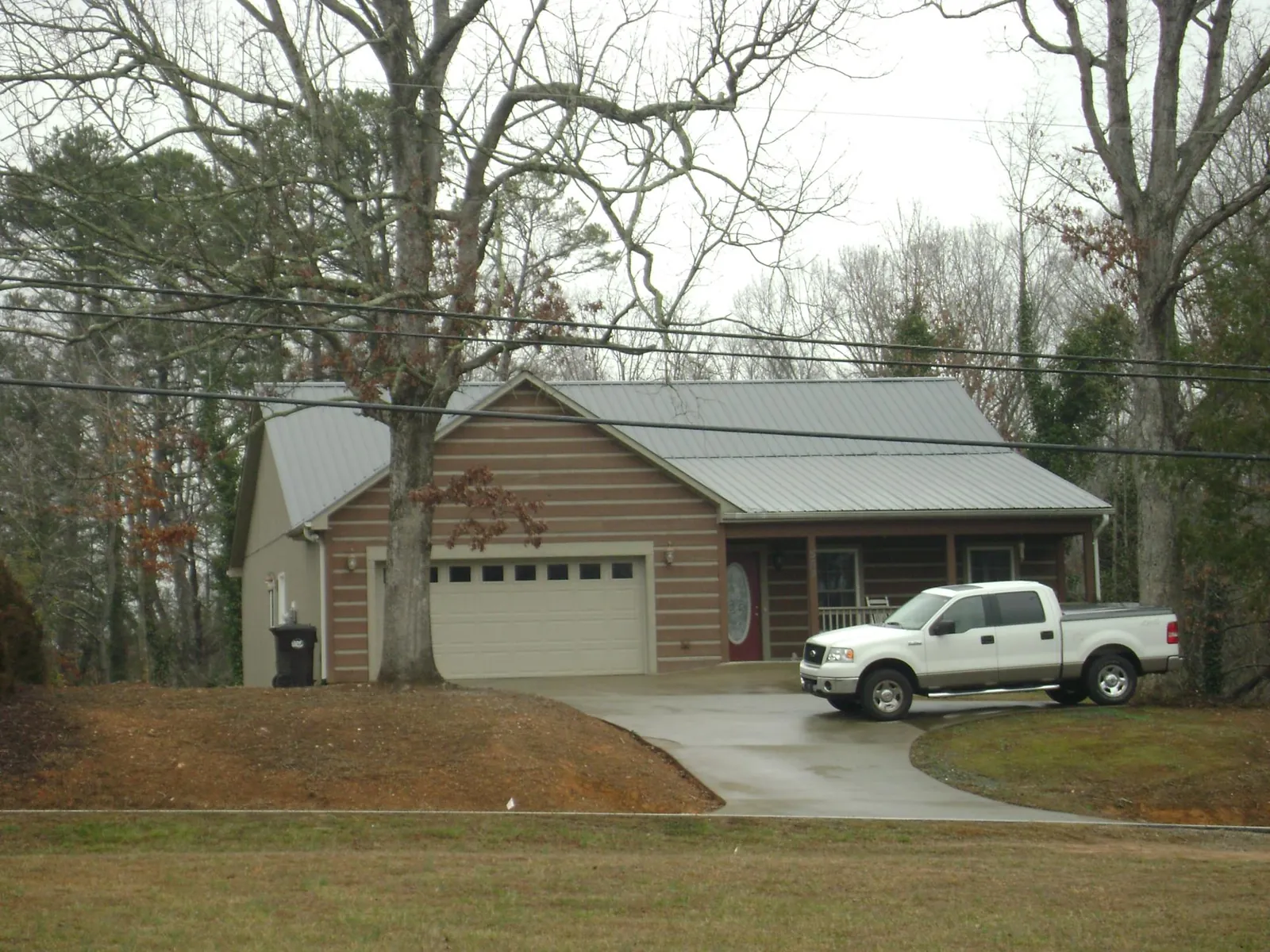 Gray metal roof on a log sided house with an attached two car garage in Marcola